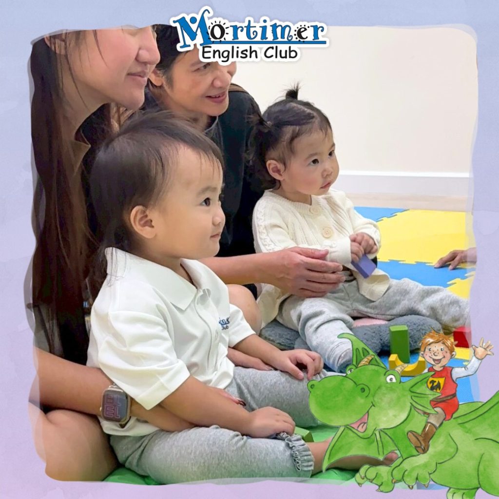 เด็กวัยเตาะแตะและผู้ปกครองตั้งใจฟังและสังเกตกิจกรรมในห้องเรียน EFLO